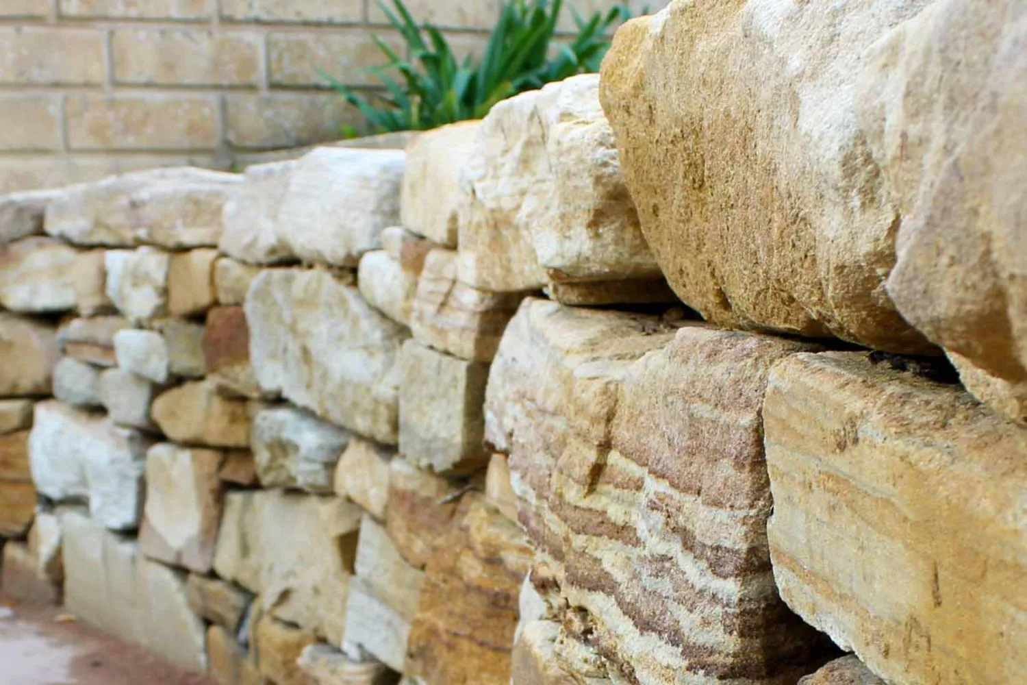 Close-up of natural sandstone rocks stacked in a dry-stone retaining wall
